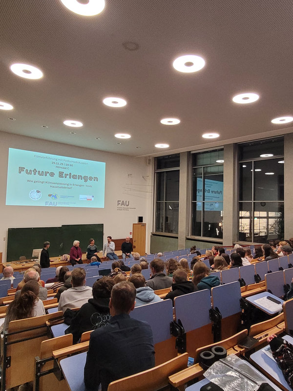 Bild des Hörsaal C während der Diskussion, Publikum ist sichtbar.