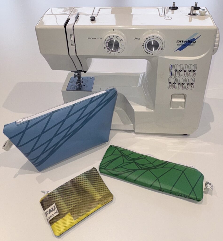 Foto einer Nähmaschine mit drei Exemplaren selbst genähter Täschchen